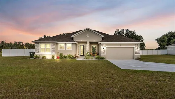 a front view of a house with a garden and yard