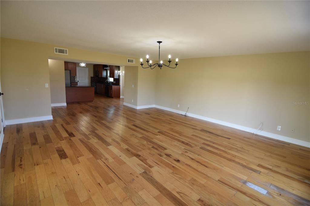 3233 Hickory Tree Road St. Cloud, FL 34772 - Photo 11 of 23 wooden floor in an empty room with a chandelier