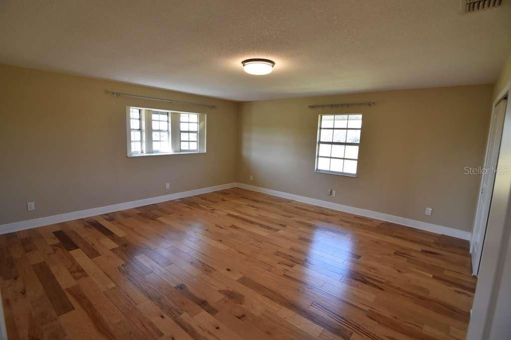 3233 Hickory Tree Road St. Cloud, FL 34772 - Photo 18 of 23 an empty room with wooden floor and windows