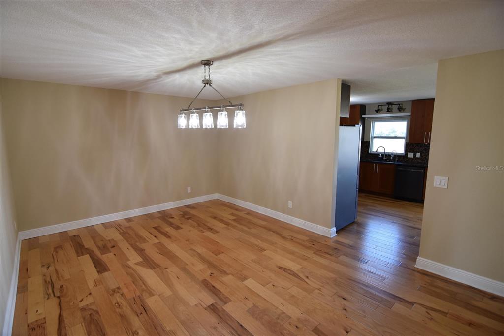 3233 Hickory Tree Road St. Cloud, FL 34772 - Photo 9 of 23 a view of an empty room with wooden floor and kitchen