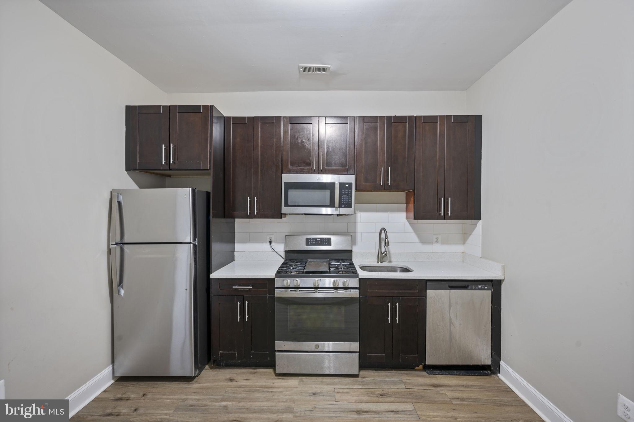 3619 Cottage Avenue Baltimore, MD 21215 - Photo 14 of 31 a kitchen with a refrigerator and a stove top oven