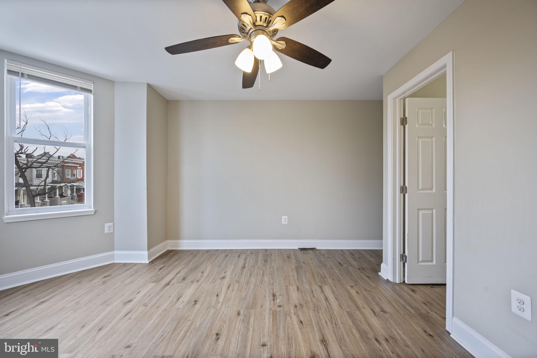 3619 Cottage Avenue Baltimore, MD 21215 - Photo 22 of 31 an empty room with wooden floor chandelier fan and windows