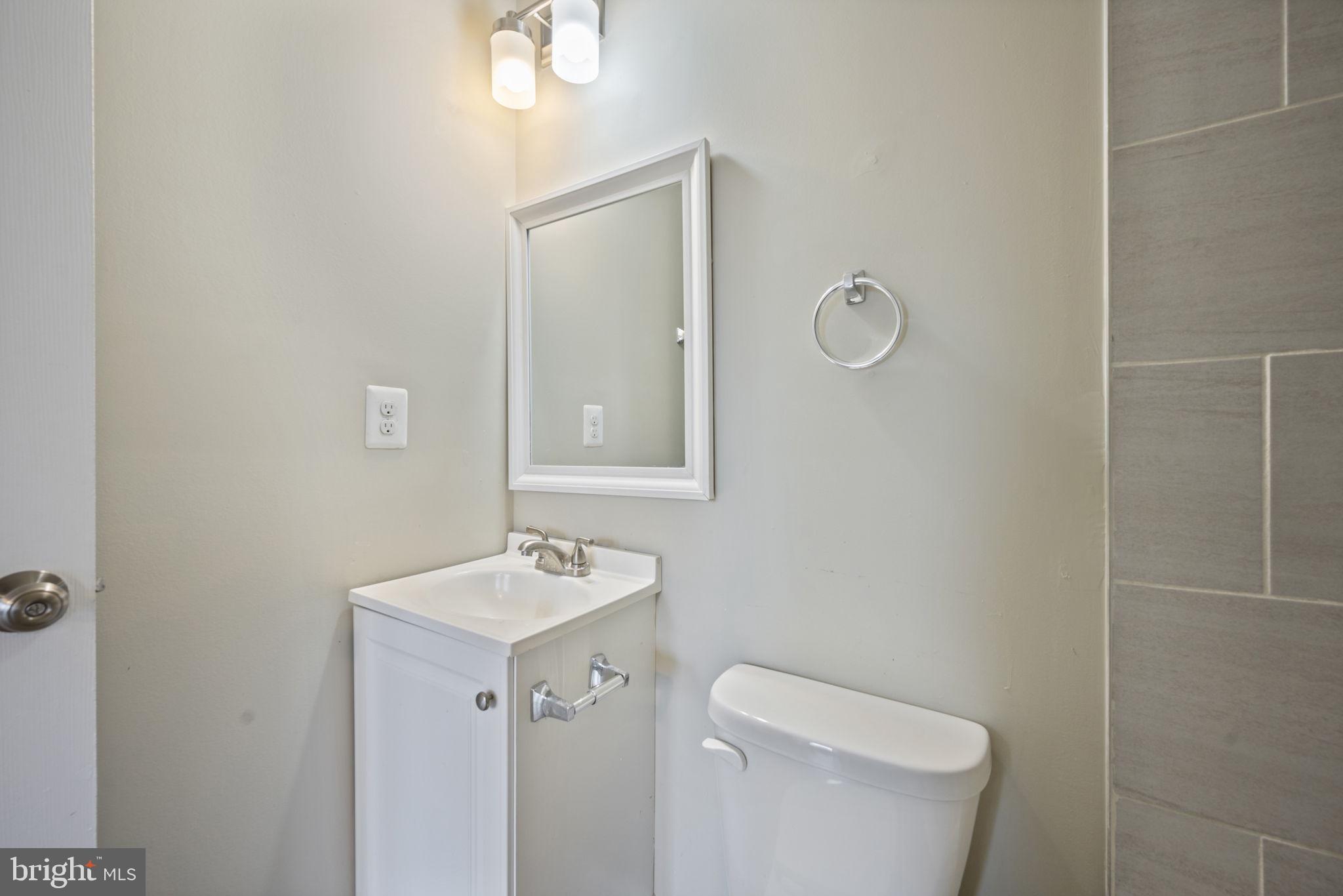 3619 Cottage Avenue Baltimore, MD 21215 - Photo 24 of 31 a bathroom with a toilet a sink a mirror and vanity