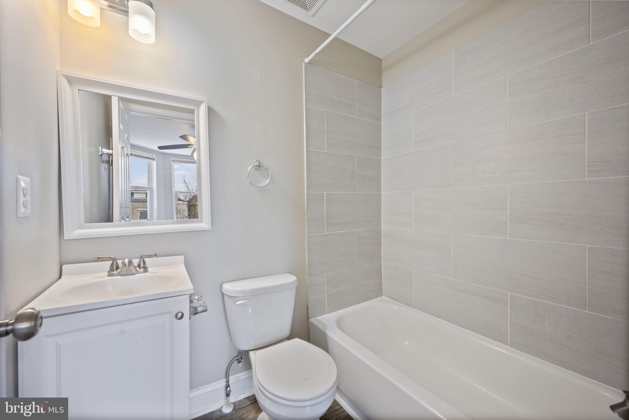 3619 Cottage Avenue Baltimore, MD 21215 - Photo 25 of 31 a white toilet sitting next to a bathroom sink