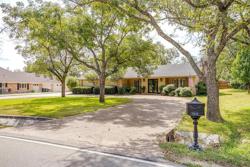 8918 Bellechase Road Granbury, TX 76049 - Photo 2 of 38 a view of a house with a yard and large trees