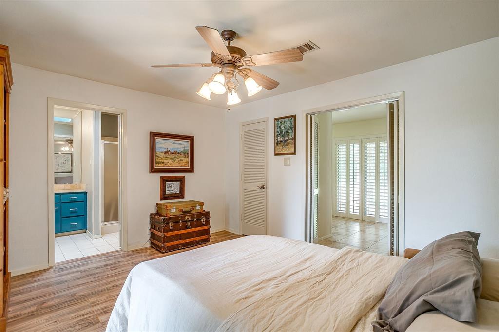 8918 Bellechase Road Granbury, TX 76049 - Photo 27 of 38 a bedroom with a bed and a chandelier