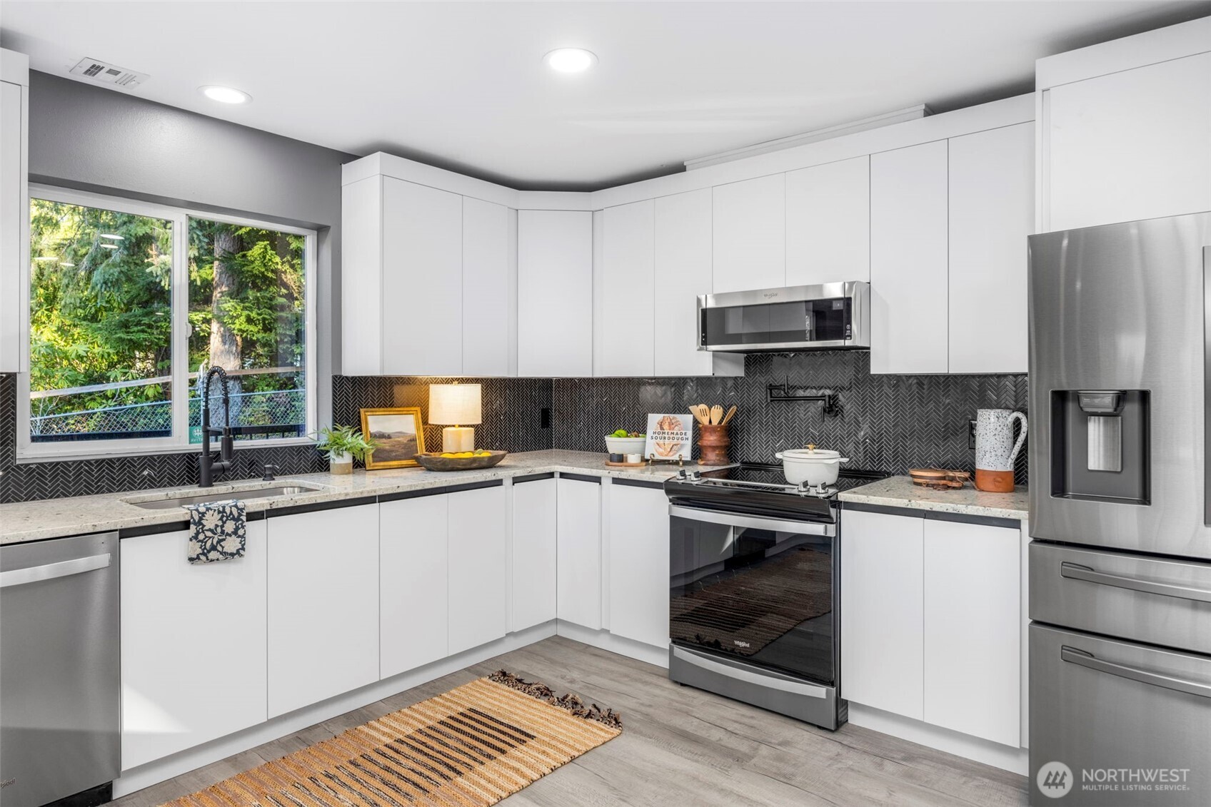 9371 Willamette Meridian Road Northwest Silverdale, WA 98383 - Photo 11 of 40 a kitchen with stainless steel appliances white cabinets a sink and a stove