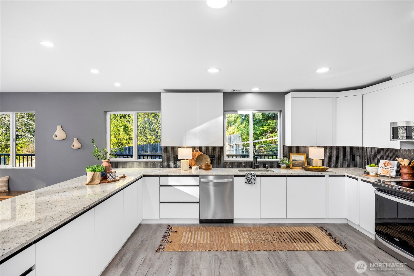 9371 Willamette Meridian Road Northwest Silverdale, WA 98383 - Photo 9 of 40 a kitchen with stainless steel appliances granite countertop wooden cabinets a sink dishwasher a stove and a refrigerator with wooden floor