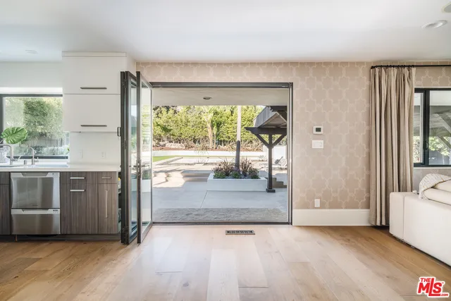 a view of front door and bedroom with wooden floor