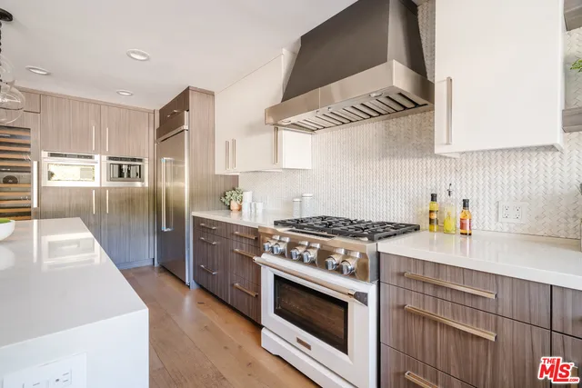 a kitchen with stainless steel appliances granite countertop a sink a stove and a refrigerator
