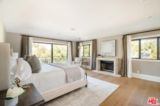 a bedroom with a large bed and a fireplace