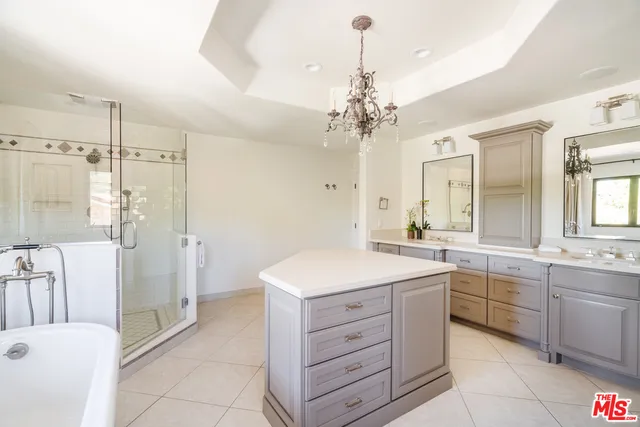 a spacious bathroom with a double vanity sink a mirror a bathtub and shower