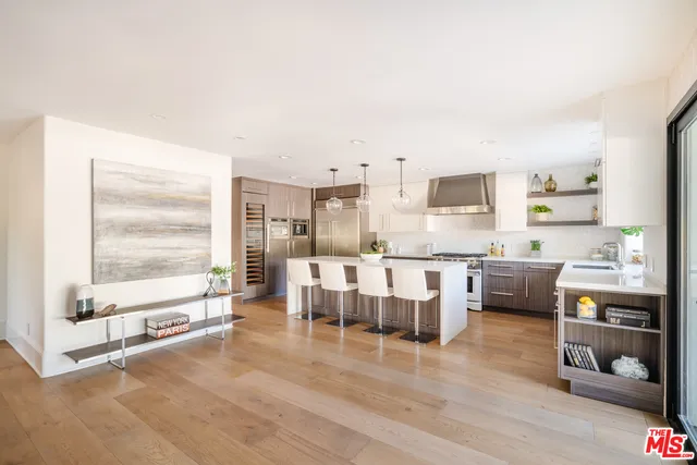 a large white kitchen with a large window and stainless steel appliances