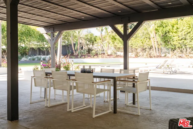 a dining room with furniture and large windows