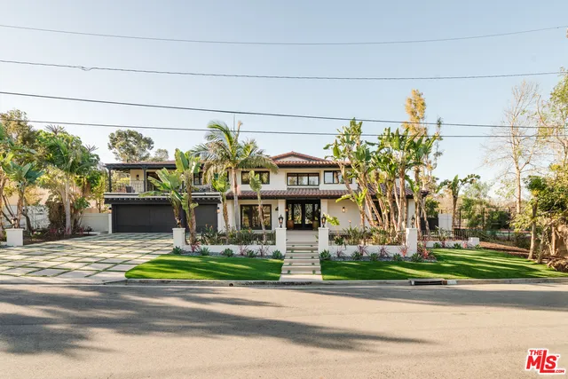 a front view of a house with a garden and plants