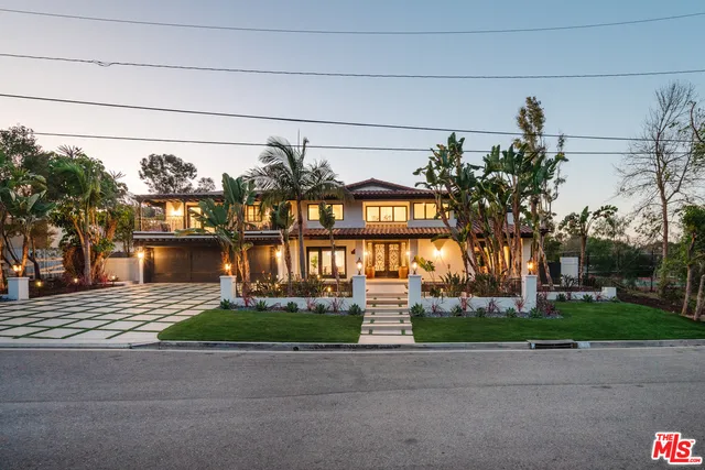 a front view of a house with a garden and plants