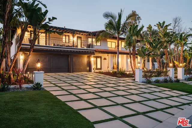 a front view of a house with a yard and potted plants