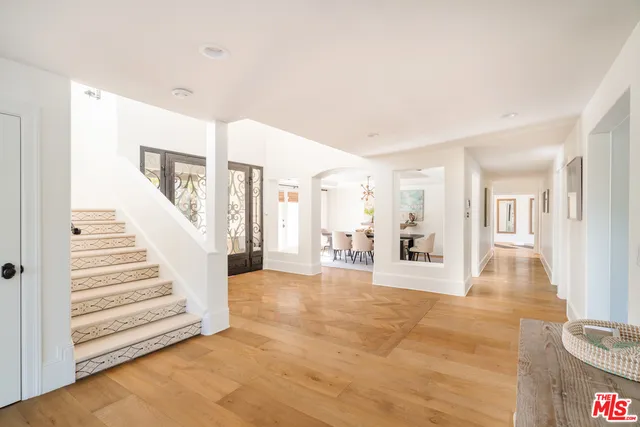 a view of a big room with wooden floor and windows
