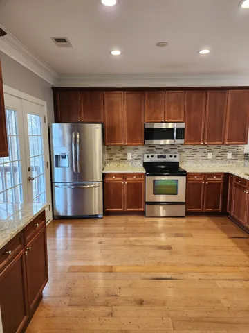 a kitchen with a wooden floor and cabinets