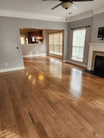 a view of a livingroom with wooden floor and a fireplace