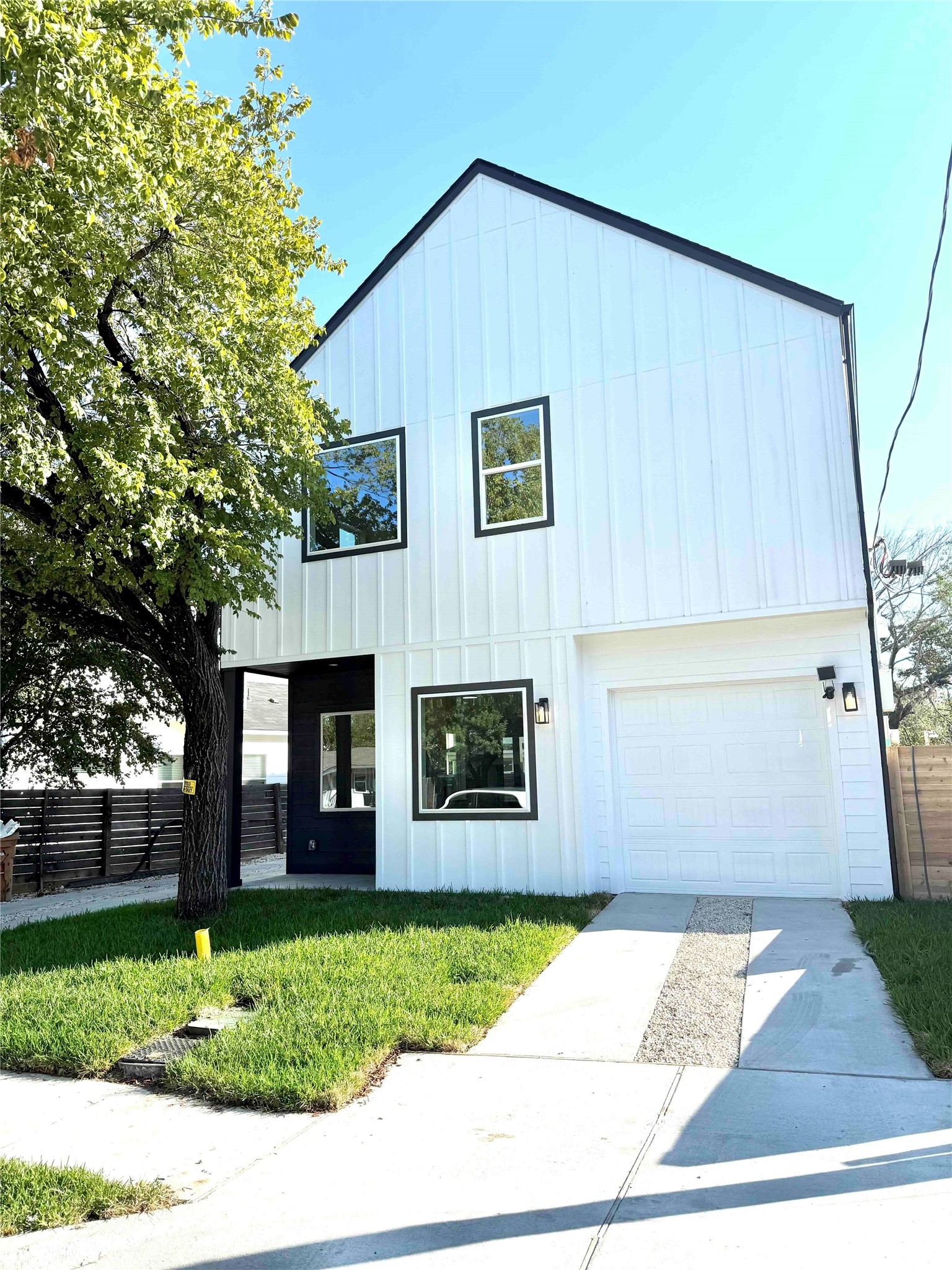 View of front of home with board and batten siding, a garage, and driveway