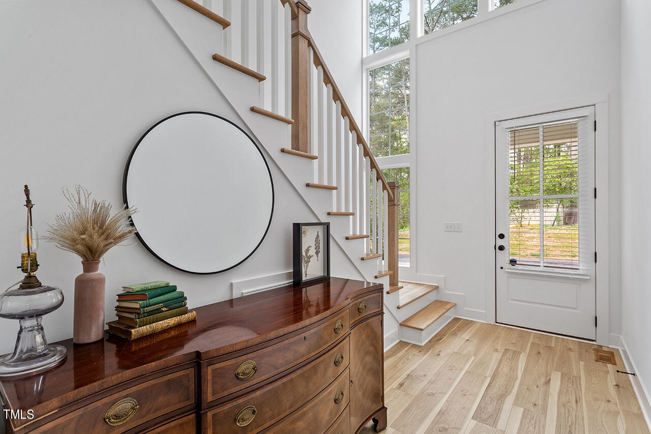 6504 Brecken Pnes Court Raleigh, NC 27612 - Photo 6 of 36 a living room with furniture a mirror and a wooden floor