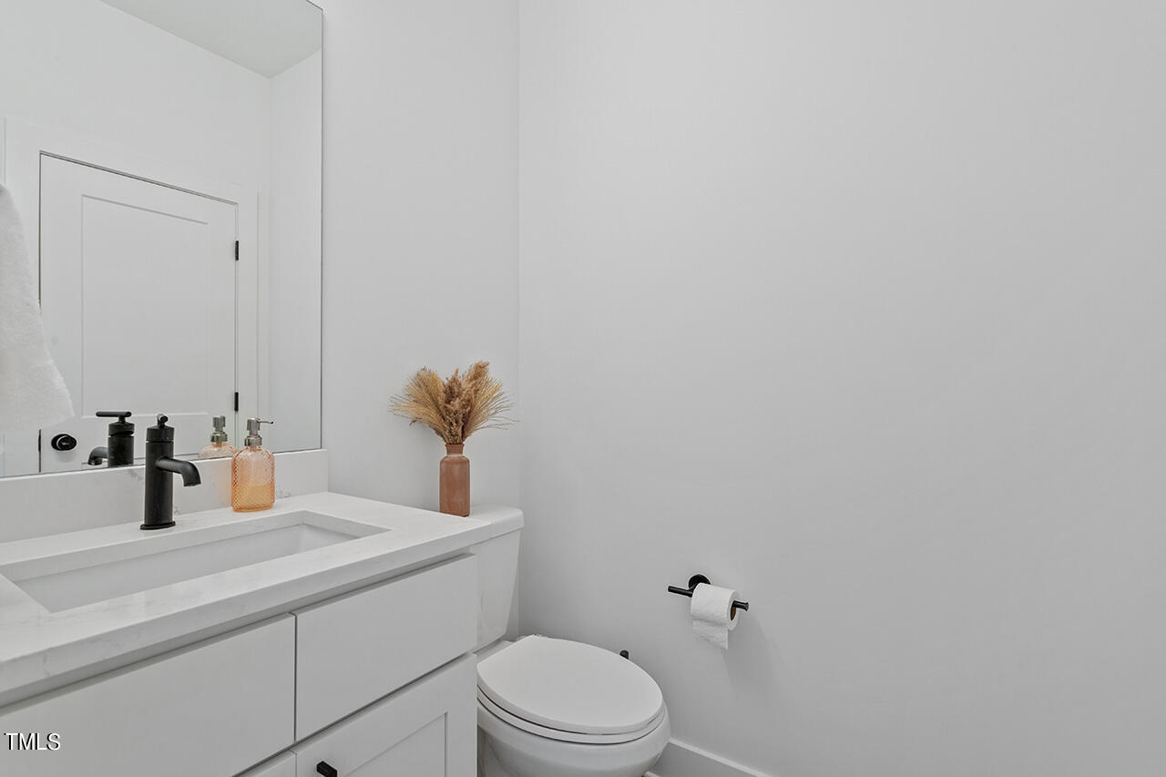 6504 Brecken Pnes Court Raleigh, NC 27612 - Photo 7 of 36 a bathroom with a sink a toilet and mirror