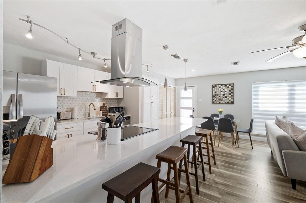 5112 Arbor Glen Road The Colony, TX 75056 - Photo 8 of 40 Kitchen with white cabinetry, stainless steel appliances, tasteful backsplash, island exhaust hood, and decorative light fixtures