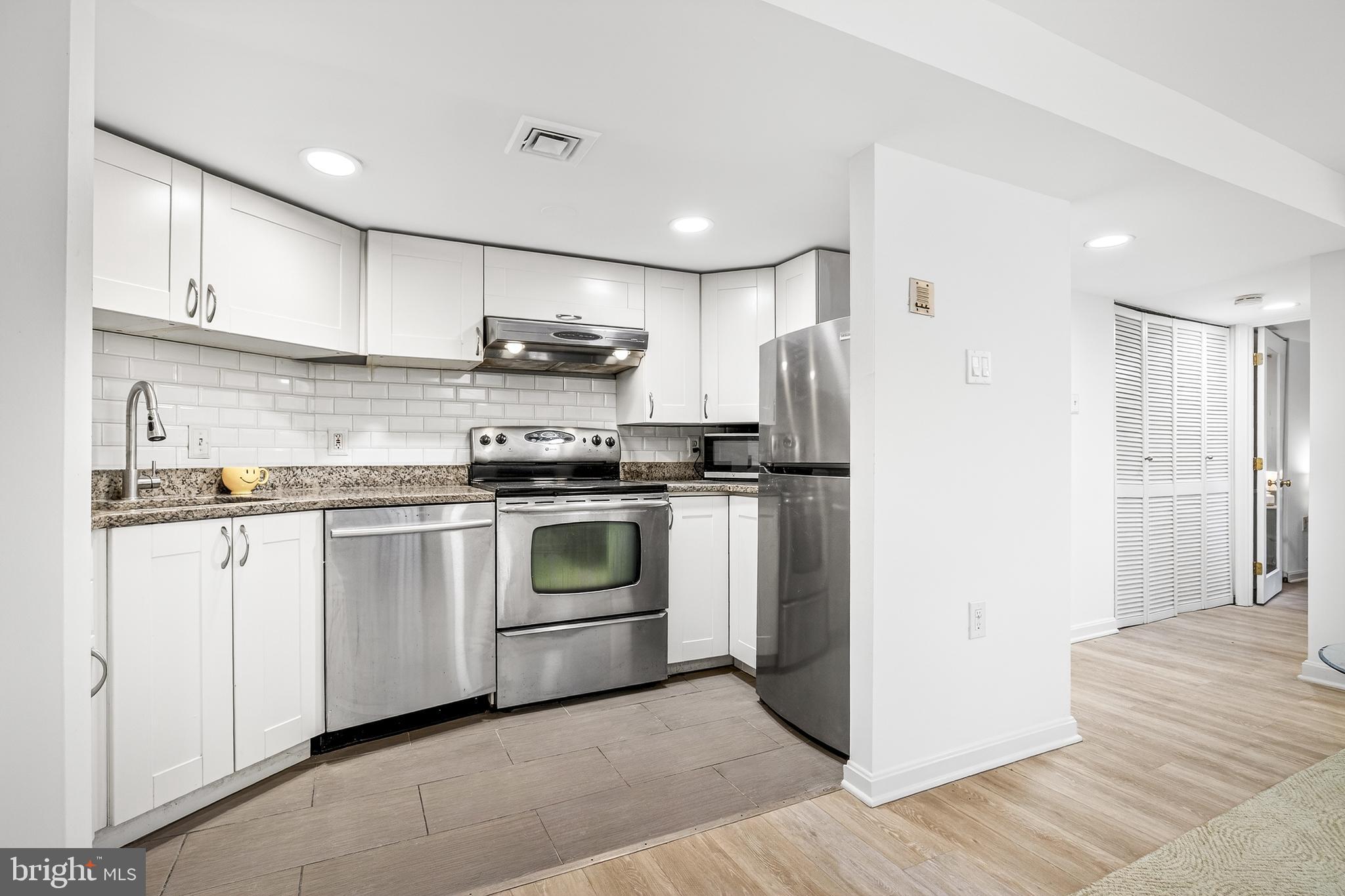 1438 Meridian Place Northwest, Unit LL1 Washington, DC 20010 - Photo 3 of 18 a kitchen with stainless steel appliances granite countertop a refrigerator sink and stove