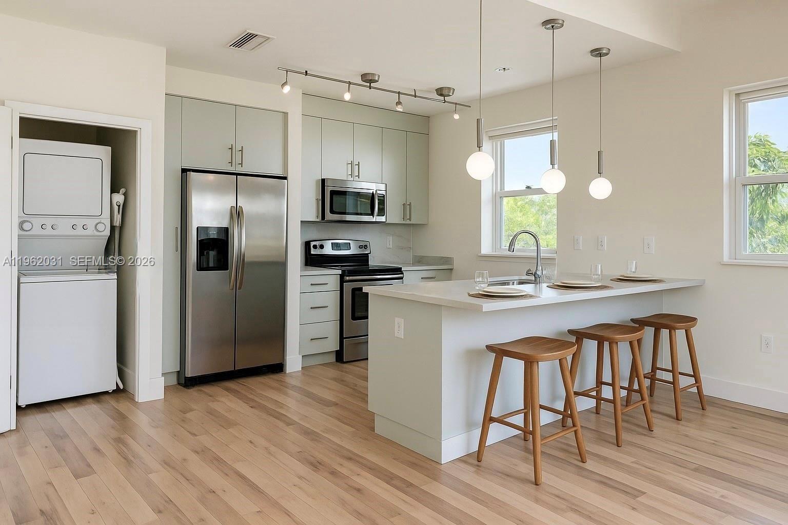 a kitchen with stainless steel appliances a sink stove refrigerator and microwave