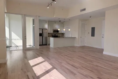 a view of a living room and kitchen with wooden floor