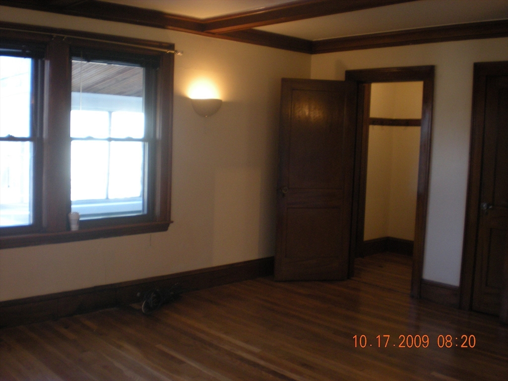 257 Common Street, Unit 2 Watertown, MA 02472 - Photo 14 of 30 a view of an empty room with wooden floor and a window