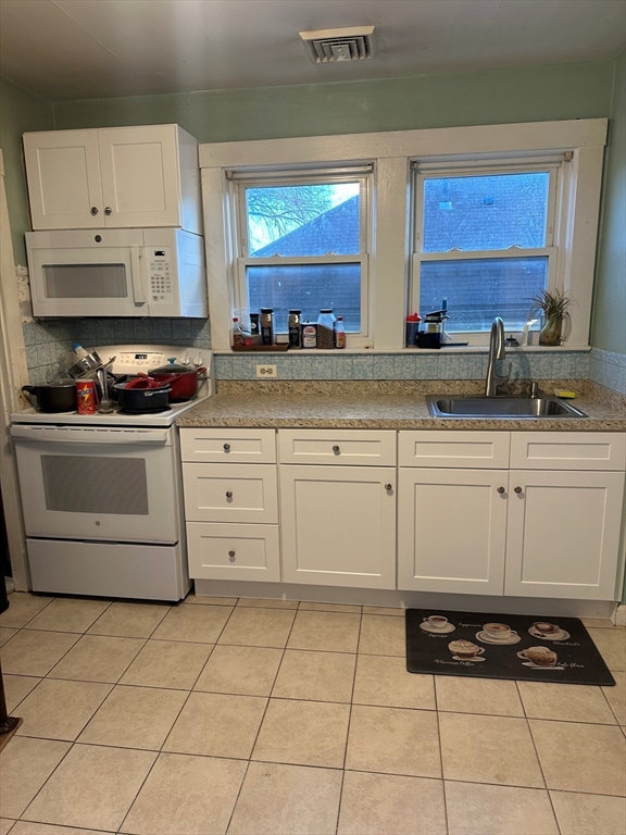 257 Common Street, Unit 2 Watertown, MA 02472 - Photo 2 of 30 a kitchen with stainless steel appliances a stove a sink and white cabinets