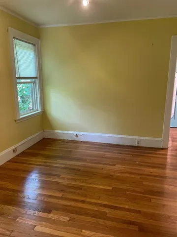 a view of a room with wooden floor and a window