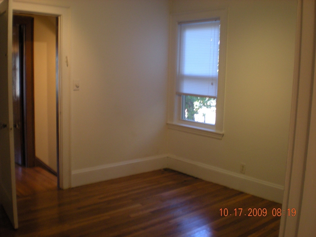 257 Common Street, Unit 2 Watertown, MA 02472 - Photo 24 of 30 a view of an empty room with wooden floor and a window
