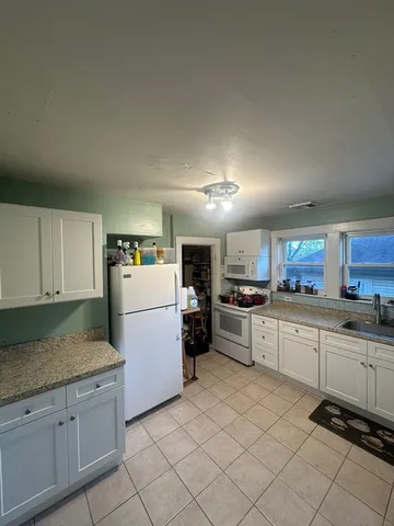 a kitchen with refrigerator and cabinets