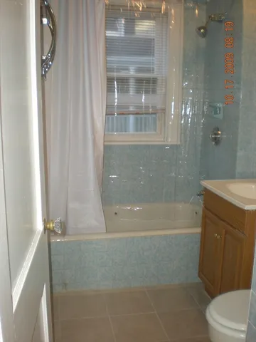 a bathroom with a granite countertop bathtub shower and toilet
