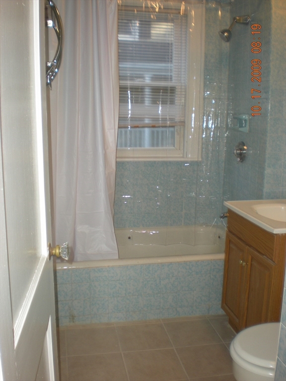 257 Common Street, Unit 2 Watertown, MA 02472 - Photo 9 of 30 a bathroom with a granite countertop bathtub shower and toilet