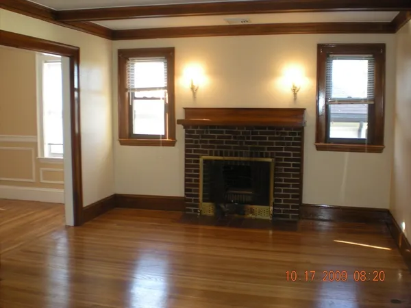 a living room with wooden floor and a fireplace