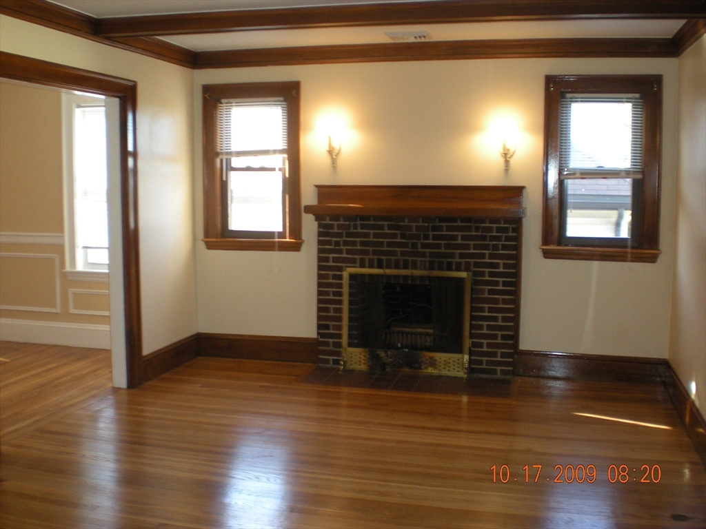 257 Common Street, Unit 2 Watertown, MA 02472 - Photo 10 of 30 a living room with wooden floor and a fireplace