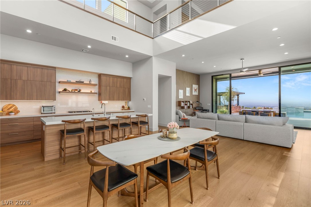 571 Overlook Rim Drive Henderson, NV 89012 - Photo 9 of 85 Dining room with recessed lighting, light wood-style flooring, a high ceiling, and a ceiling fan