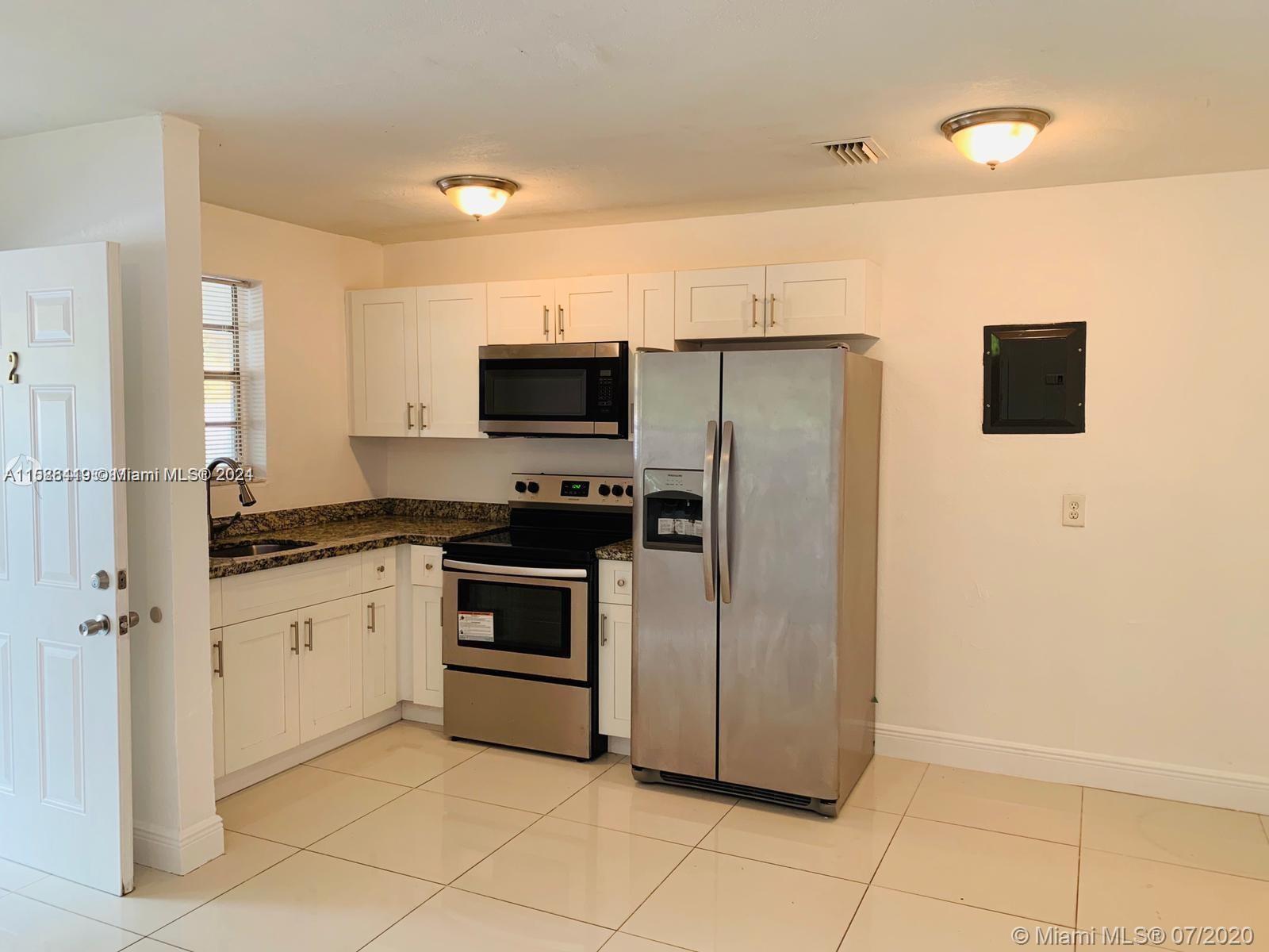 a kitchen with stainless steel appliances a refrigerator sink and microwave