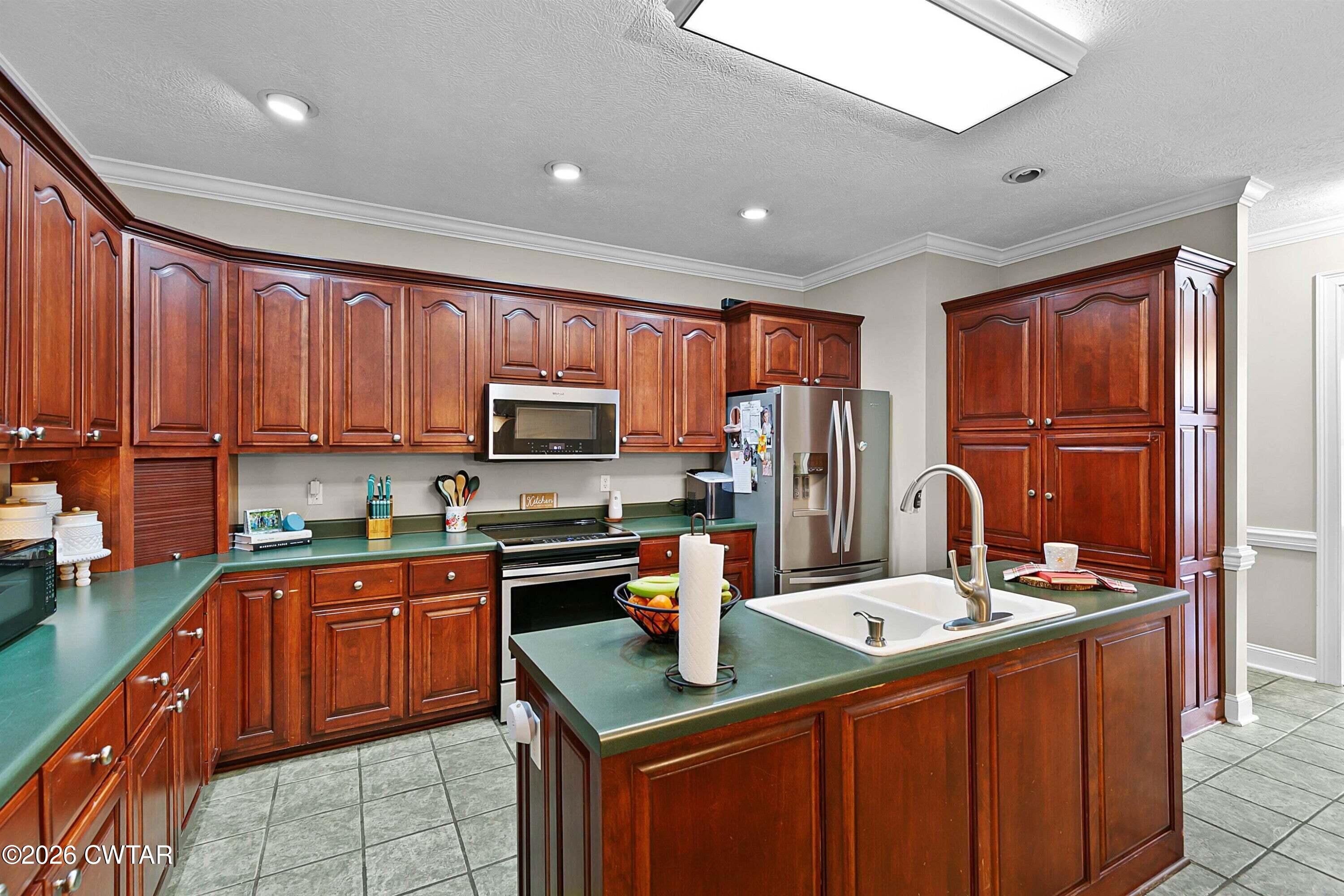 255 Oak Ridge Drive Henderson, TN 38340 - Photo 11 of 23 a kitchen with stainless steel appliances granite countertop a sink stove refrigerator and cabinets