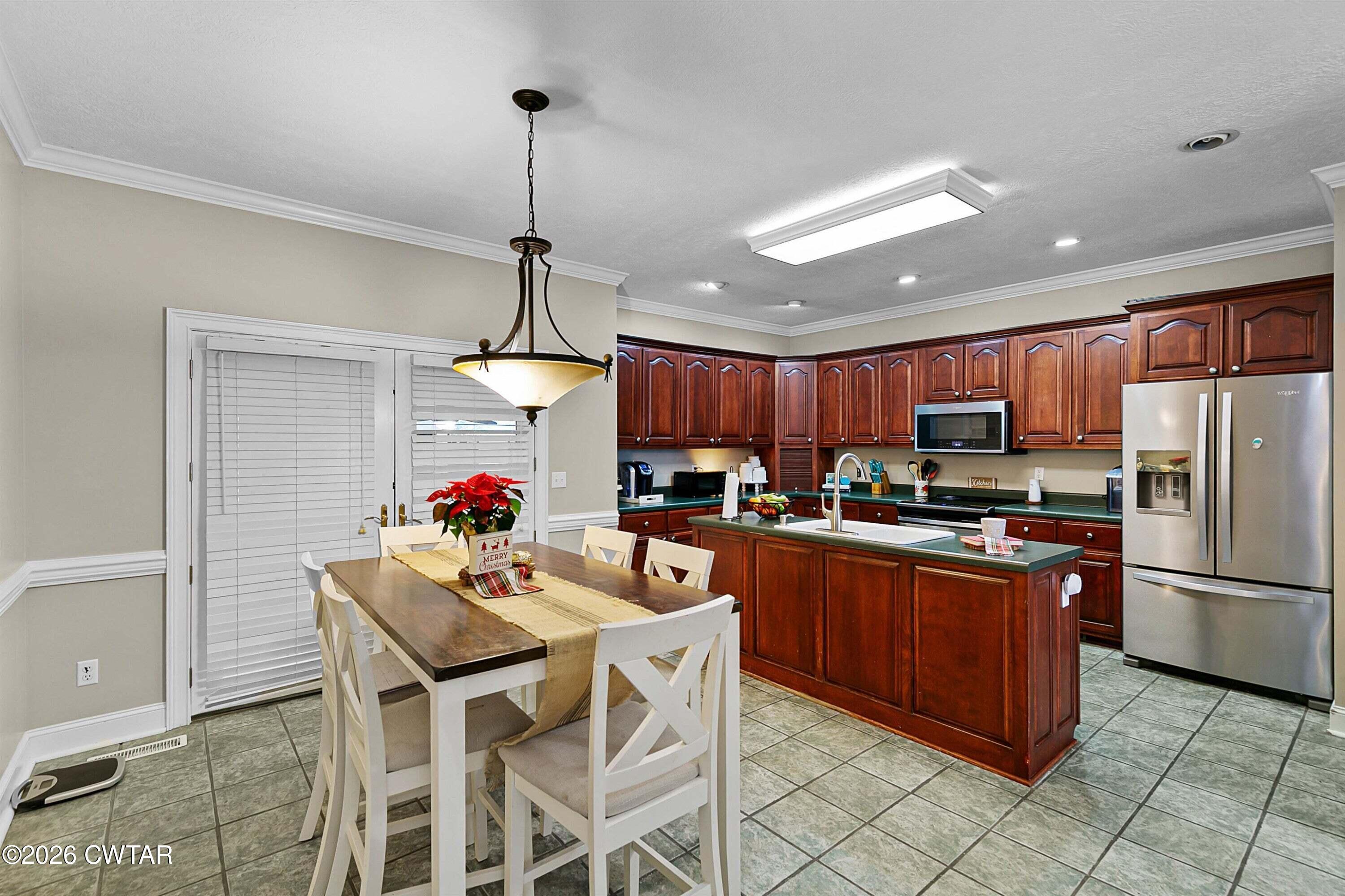 255 Oak Ridge Drive Henderson, TN 38340 - Photo 9 of 23 a kitchen with stainless steel appliances granite countertop a refrigerator a sink dishwasher a dining table and chairs with wooden floor