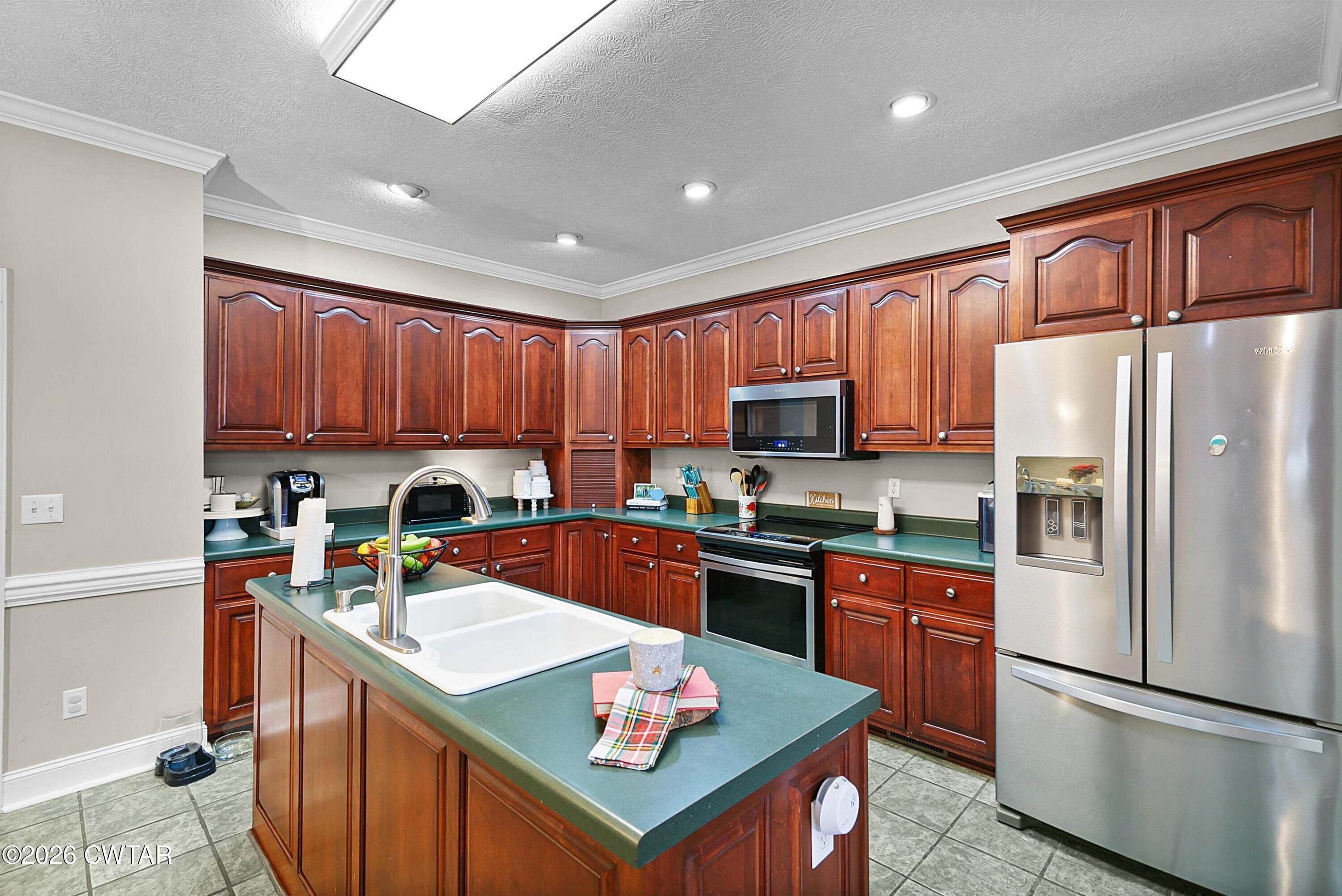 255 Oak Ridge Drive Henderson, TN 38340 - Photo 10 of 23 a kitchen with stainless steel appliances granite countertop a refrigerator stove microwave sink and cabinets