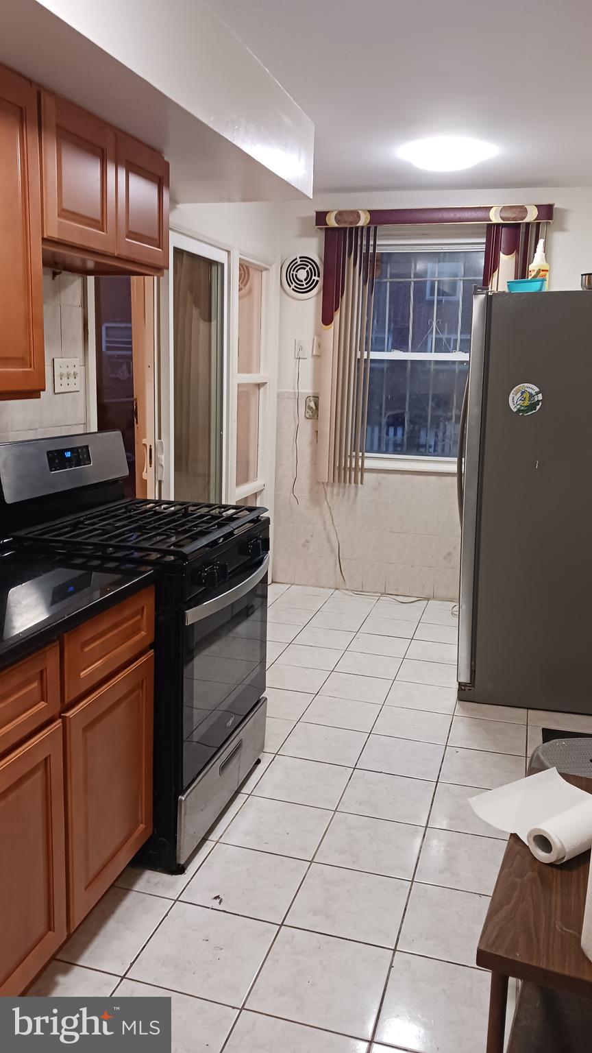 7239 Hanford Street Philadelphia, PA 19149 - Photo 12 of 16 a kitchen with granite countertop a refrigerator and a stove top oven