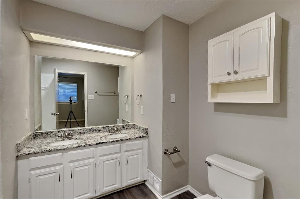5217 Hollow Bend Lane Garland, TX 75043 - Photo 11 of 18 a bathroom with a granite countertop toilet sink and mirror