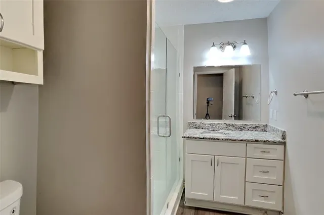 a bathroom with a granite countertop sink and a mirror