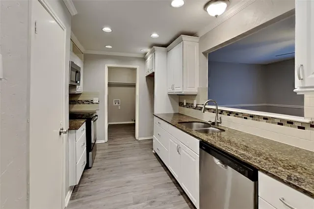 a kitchen with granite countertop a sink and cabinets