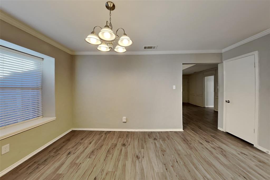 5217 Hollow Bend Lane Garland, TX 75043 - Photo 8 of 18 a view of a room with wooden floor and chandelier
